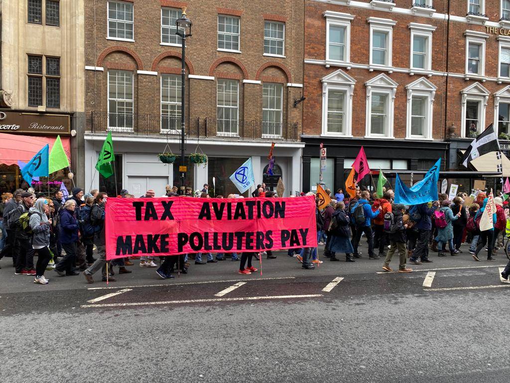 People holding banner stating "Tax aviation, Make Polluters Pay"