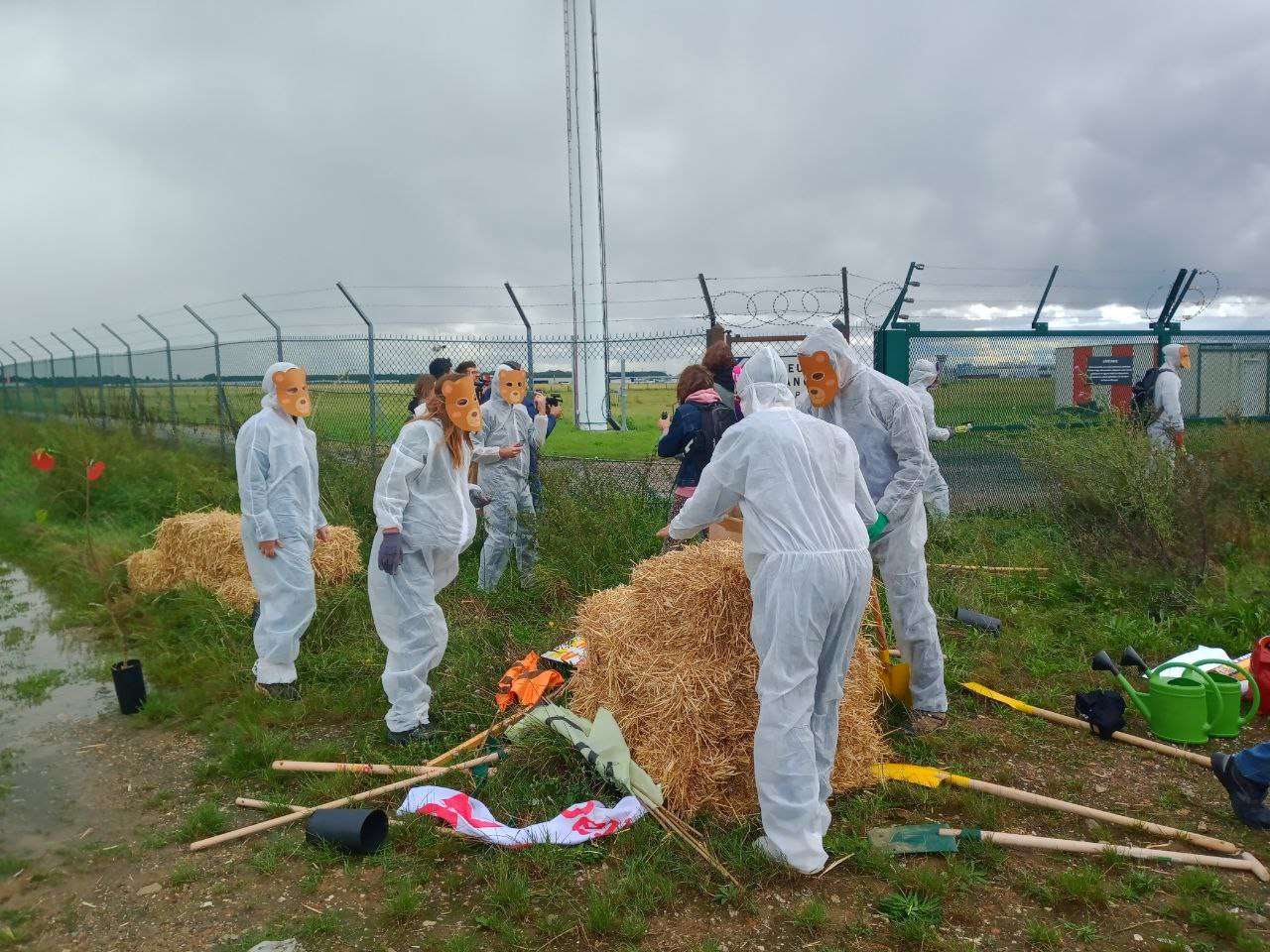 Activists dressed in white and wearing animal masks enter Le Bourget airport