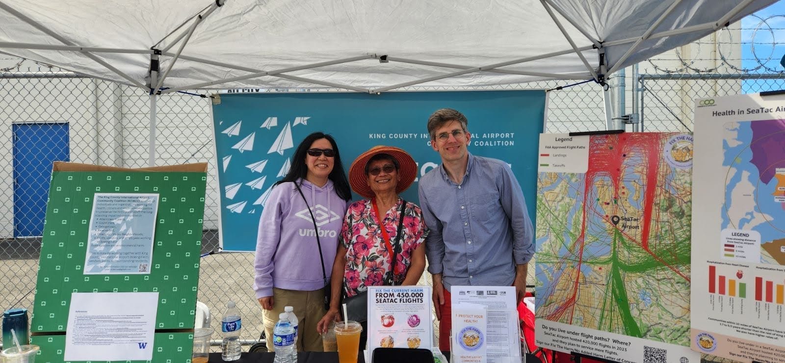 Three campaigners from the struggle against King County International Airport tabling at a local community resource fair